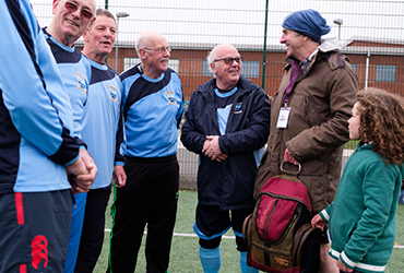 CAREGiver talking to a football team of senior men