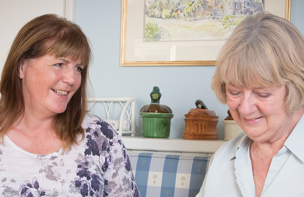 Daughter and her elderly mother happily eating a meal together