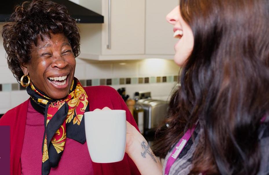 Client and CAREGiver laughing whilst drinking tea